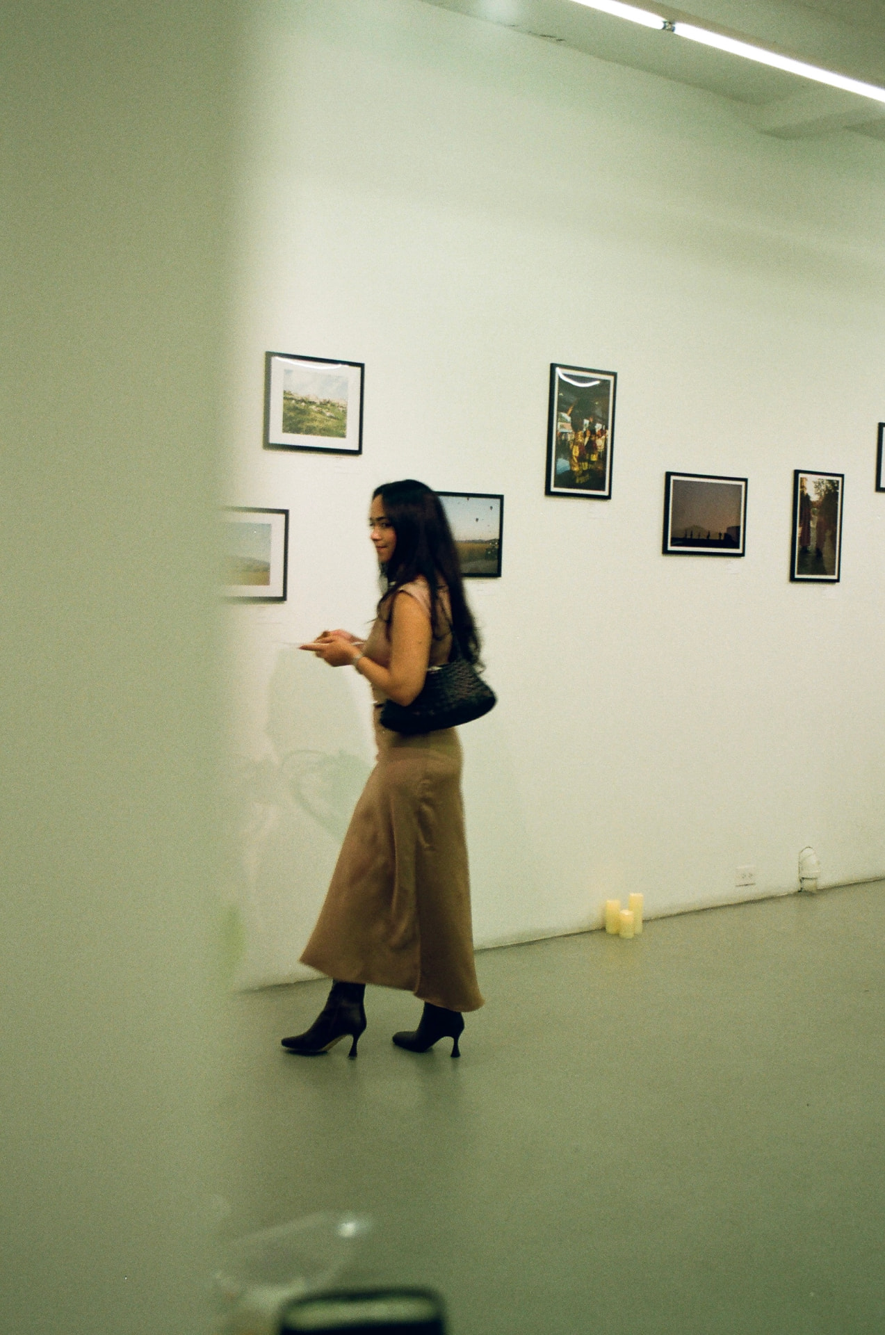 A guest pausing mid-step in a quiet gallery of framed photographs